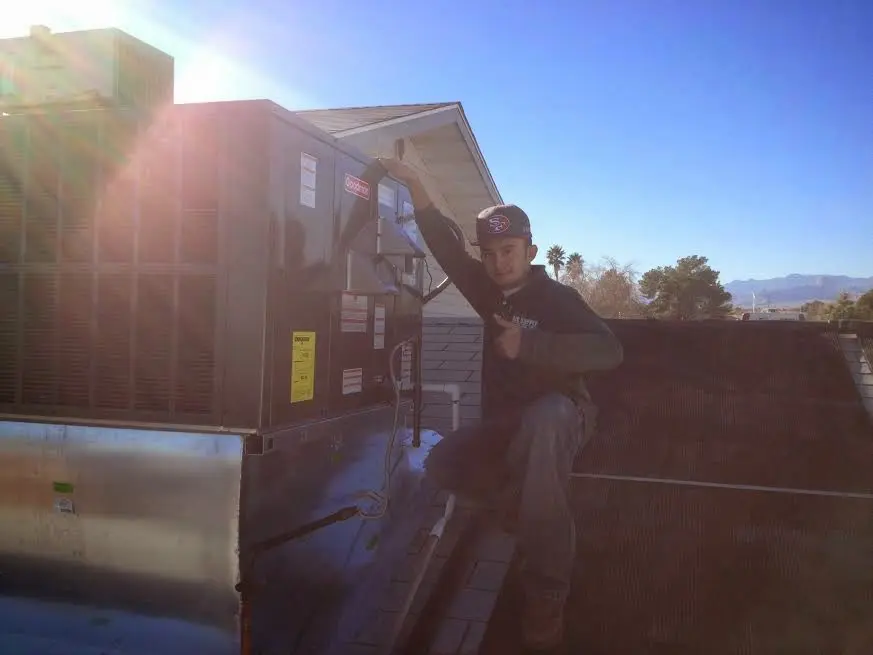 HVAC technician performing HVAC Inspection on a rooftop unit in Howell